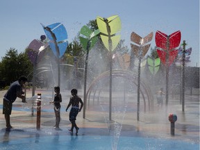 People take a break from the heat at the L'Aquaciel splash pad in LaSalle.