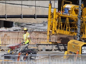 Crews work on the deck of the Décarie Expressway southbound lanes connecting to the Champlain Bridge access as part of the Turcot Interchange project in Montreal, June 29, 2018.