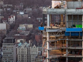 MONTREAL, QUE.: DECEMBER 7, 2015 -- Construction workers on the L'Avenue condo tower seen from the 47th floor of the new Tour des Canadiens in downtown Montreal on Monday, December 7, 2015.