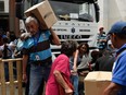 Employees of the University Hospital carry their boxes with basic goods provided by the government program "CLAP" (Local Committees for Supply and Production), outside the hospital, in Caracas on June 26, 2018. Venezuelan President Nicolas Maduro's socialist government is in the midst of an ever-deepening crisis with food and medicine in short supply.