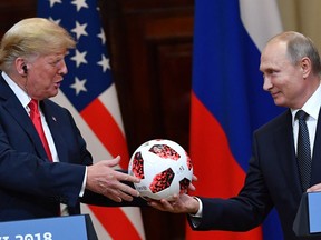 TOPSHOT - Russia's President Vladimir Putin (R) offers a ball of the 2018 football World Cup to US President Donald Trump during a joint press conference after a meeting at the Presidential Palace in Helsinki, on July 16, 2018. The US and Russian leaders opened an historic summit in Helsinki, with Donald Trump promising an "extraordinary relationship" and Vladimir Putin saying it was high time to thrash out disputes around the world.