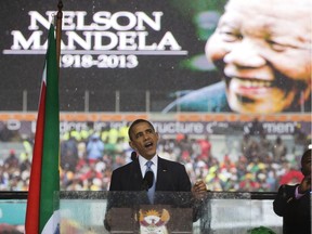 FILE -- In this Tuesday, Dec. 10, 2013, file photo, former U.S. President Barack Obama speaks to crowds attending the memorial service for former South African President Nelson Mandela, background, in Soweto, Johannesburg. In a speech marking the 100th birthday of anti-apartheid leader Nelson Mandela on Tuesday, July 17, 2018, former U.S. President Barack Obama will urge youth around the world to work for human rights and fair societies, highlighting the late South African leader's example of persevering in the struggle for democracy and equal rights for all.