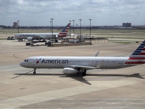 FILE - In this June 16, 2018 file photo, American Airlines aircrafts are seen at Dallas-Fort Worth International Airport in Grapevine, Texas. American Airlines says it will stop using plastic straws and drink stirs and replace them with biodegradable alternatives. American said Tuesday, July 10, 2018, that starting this month in its airport lounges it will serve drinks with straw and wood stir sticks and begin moving to what it called eco-friendly flatware.