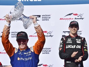 Scott Dixon hoists the trophy after winning the Honda Indy, as third-place finisher Robert Wickens looks on in Toronto on Sunday, July 15, 2018.