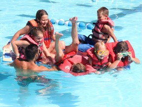 Kids fall out of a foam boat into the deep end of a pool to practise their water-survival skills in Cornwall, Ont.