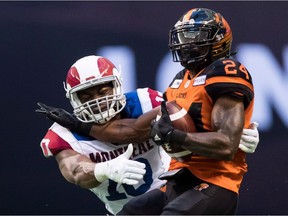 B.C. Lions' Jeremiah Johnson, right, is tackled by Montreal Alouettes' Henoc Muamba in Vancouver, on June 16, 2018. He's one of the CFL's top defensive players and among its leading tacklers, but Henoc Muamba didn't always enjoy the physical aspect of the game. In fact, early in his football career the linebacker went to great lengths to avoid being hit.