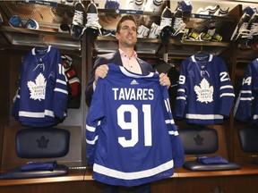 John Tavares displays his new Toronto Maple Leafs sweater in team’s locker room after signing a seven-year, US$77-million contract with the team as a free agent on July 1, 2018.