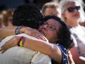 Lila Cabrera, who teaches English to refugees, hugs Kibrom Milash, after his comments to a crowd of people, as they gathered for a vigil at City Hall in Boise, Idaho, Monday, July 2, 2018. A 3-year-old Idaho girl who was stabbed at her birthday party died Monday, two days after a man invaded the celebration and attacked nine people with a knife, authorities said.