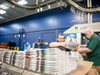 Workers stack newspapers at the Janesville Gazette Printing & Distribution plant in Janesville, Wisconsin. U.S. newspaper companies say they are struggling after the White House imposed tariffs on Canadian newsprint.
