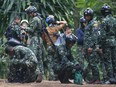 Thai rescuers prepare to enter the cave where 12 boys and their soccer coach have been trapped since June 23, in Mae Sai, Chiang Rai province, in northern Thailand Friday, July 6, 2018.