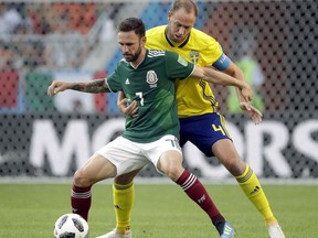 FILE - In this Wednesday, June 27, 2018 file photo Mexico's Miguel Layun, left, and Sweden's Andreas Granqvist, right, challenge for the ball during the group F match between Mexico and Sweden, at the 2018 soccer World Cup in the Yekaterinburg Arena in Yekaterinburg , Russia. Day by day, the heavyweights of international football are dropping out of the World Cup. And it's giving countries like Sweden reason to dream.
