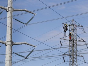 Hydro-Québec crews change the insulators on a series of transmission towers in Montreal. The utility is seeking a slim 0.8 rate hike this year.