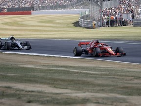 Ferrari driver Sebastian Vettel of Germany, right, steers his car followed by Mercedes driver Lewis Hamilton of Britain during the British Formula One Grand Prix at the Silverstone racetrack, Silverstone, England, Sunday, July 8, 2018.