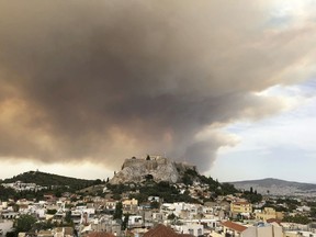 A pall of smoke turns large parts of the sky orange, with the ancient Acropolis hill at centre, as a forest fire burns in a mountainous area west of Athens, sending nearby residents fleeing, Monday, July 23, 2018.