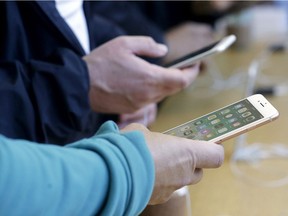 Customers look at iPhone 8 and iPhone 8 Plus phones at an Apple Store in San Francisco, Friday, Sept. 22, 2017.