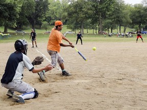 Jonathan Burnham hits the ball during exhibition softball game between local players and Expos Nation at Jeanne Mance Park in Montreal Saturday July 14, 2018.  The event was held in response to the Plateau Mont-Royal's decision to close the north softball field in the same park.