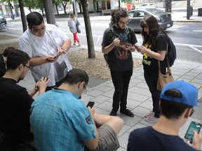 Pokemon GO players Nicolas Lafleur, middle, from Mascouche and Sabrina De Billy of Repentigny, right, at Square Victoria in Montreal in 2016. There's a Montreal-centric Pokemon GO Facebook group.