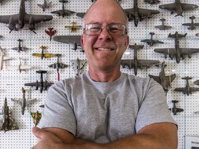 Ted's Hobby Shop owner Peter Grant poses in front of the store's eye-catching display of model military aircraft.
