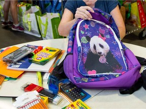 Volunteers are filling backpacks at the West Island Mission. The distribution is Aug. 11.