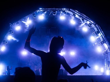 Arianne Regimbald is silhouetted against the Scène Neon on Day 1 of the ÎleSoniq music festival at Parc Jean-Drapeau on Friday Aug. 10, 2018.