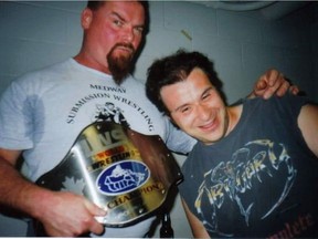 Jim "The Anvil" Neidhart, who died Monday, embraces Montreal wrestler Manny Eleftheriou after a 2002 event in Deux Montagnes, QC.