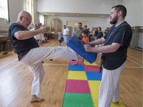 André Langevin, left, demonstrates a martial arts move with his son Philippe, right, at Valois United Church.