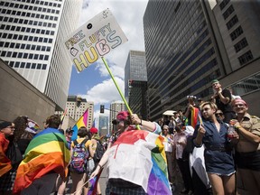 A spectator grabs a hug while she watches the Pride Parade in Montreal on Aug. 19, 2018.