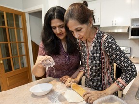 Meena Khan and her mother, Nikhat Khan, make chapatis in their home. Living at home allows her to help look after her aging parents, Meena Khan says.