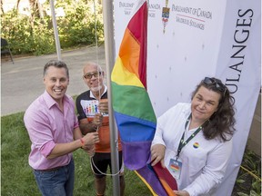 MP Peter Schiefke (left), Pincourt Mayor Yvan Cardinal (centre) and Julie Lemieux, the first known transgender person to be elected as a mayor in Canada, from the small village of Très-Saint-Rédempteur, raise the gay Pride flag at Schiefke's riding office in Vaudreuil-Dorion on Sunday.