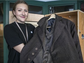 Kate Bauer holds up a replica of a men's sack suit, the type of garment manufactured in Montreal in the first part of the 20th century by Harris Vineberg's Progress Brand.