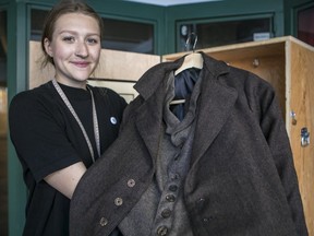 Kate Bauer holds up a replica of a men's sack suit, the type of garment manufactured in Montreal in the first part of the 20th century by Harris Vineberg's Progress Brand.

MONTREAL, QUE.: AUGUST 19, 2018 --Kate Bauer is seen here with a replica of a men's sack suit, the type of garment manufactured in Montreal in the first part of the 20th century by Harris Vineberg's Progress Brand. The factory was located in what was then the Vineberg bulding, on the northwest corner of St-Laurent Blvd. and Duluth St. Today it is a mixed-use building; the Museum of Jewish Montreal. which takes up part of the ground floor, has mounted a tour that looks at the garment (shmatte) industry of the early 20th century through the lens of Progress Brand, incorporating history, business, culture and the labour movement. Bauer helped to research the content of the exhibit and served as a guide. In Montreal, On Sunday, August 19, 2018. (Dave Sidaway / MONTREAL GAZETTE) ORG XMIT: 61215Museum of Jewish Montreal has mounted a new tour that looks at history, business, culture and the labour movement as it applied to the garment (shmatte) industry of the early 20th century. On Sunday, August 19, 2018. (Dave Sidaway / MONTREAL GAZETTE) ORG XMIT: 61215