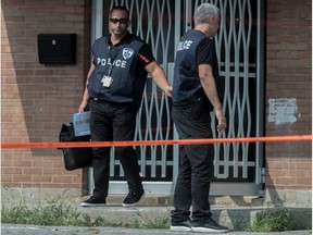 Police exit the front entrance of a building at Lafrenaie and Magloire Sts. in St-Léonard on Friday where Guy Therrien was killed the night before. (Dave Sidaway / MONTREAL GAZETTE)