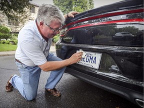Ryk Edelstein cleans the vanity licence plate on his Dodge Charger at his home in Montreal. His wife is unimpressed with his choice.