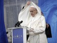 An aide adjusts Pope Francis' cape as he delivers his speech at the Knock Shrine, in Knock, Ireland, Sunday, Aug. 26, 2018.