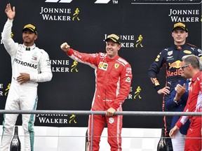Ferrari driver Sebastian Vettel of Germany, center, jubilates on the podium after winning the Belgian Formula One Grand Prix in Spa-Francorchamps, Belgium, Sunday, Aug. 26, 2018. Mercedes driver Lewis Hamilton of Britain, left, placed second and Red Bull driver Max Verstappen of the Netherlands, right, placed third.