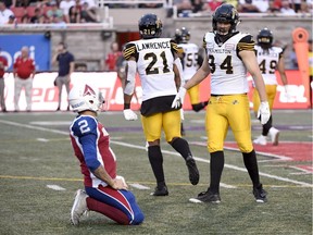 Hamilton Tiger-Cats defensive end Justin Capicciotti (94) and linebacker Simoni Lawrence (21) celebrate a pass interception as Montreal Alouettes quarterback Johnny Manziel (2) looks on during first quarter CFL football action in Montreal on Friday, August 3, 2018.