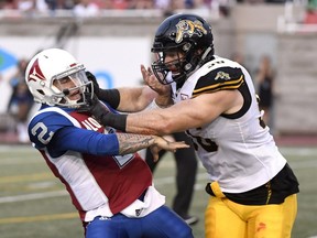 Alouettes quarterback Johnny Manziel is hit by Tiger-Cats' Jason Neill Friday night at Molson Stadium. Manziel was frequently running for his life behind the Als' porous offensive line during the game.