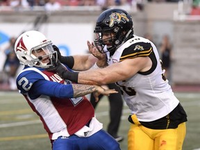 Montreal Alouettes quarterback Johnny Manziel is hit by Hamilton Tiger-Cats defensive-end Jason Neill during first quarter in Montreal on Aug. 3, 2018.