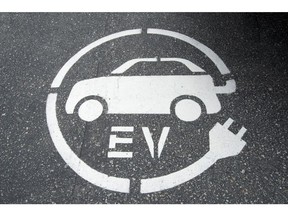An electric vehicle charging sign is pictured in Squamish, B.C., Tuesday, June, 1, 2016. Cost and supply are the main challenges keeping Canadians from buying more electric vehicles, a survey of car sales reps suggests.