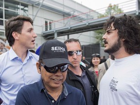 Prime Minister Justin Trudeau, left, is confronted by Matthieu Brien, 31, during a visit to a Quebec's Fete nationale holiday celebration in Montreal, Saturday, June 23, 2018.