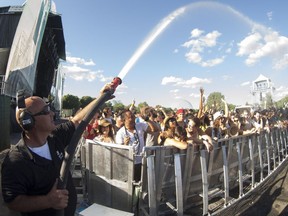 A security guard cools off music fans during the Franz Ferdinand performance at Osheaga in 2012.