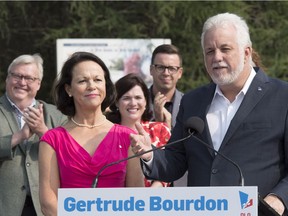 Quebec Liberal Leader Philippe Couillard announces that Jean-Lesage candidate Gertrude Bourdon would become health minister in a Liberal government, in Quebec City on Friday, August 24, 2018. Gaétan Barrette, left, applauds in the background.