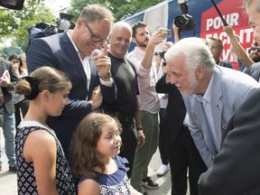 Quebec Liberal Leader Philippe Couillard, right, with Neuville Mayor Bernard Gaudreau and Gaudreau’s children on Saturday, Aug. 25.