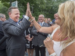 Coalition Avenir Quebec Leader Francois Legault high fives Denise Coderre after speaking with her about financial assistance for those caring for handicapped relatives, Sunday, August 26, 2018 in Terrebonne.