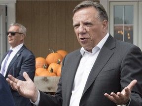 Coalition Avenir Québec Leader François Legault speaks to the owner while visiting a fruit and vegetable producer, Thursday, Aug. 30, 2018 in St-Henri.