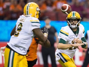 Edmonton Eskimos quarterback Mike Reilly, right, tosses the ball to C.J. Gable during second-half action against the B.C. Lions in Vancouver on Aug. 9, 2018.
