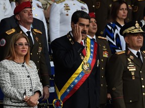Venezuelan President Nicolas Maduro (centre) gestures next to his wife, Cilia Flores, (left) during a ceremony in support of the National Guard in Caracas on Saturday, Aug. 4, 2018.