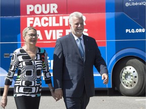 Quebec Liberal Leader Philippe Couillard walks, with wife Suzanne Pilote, to a news conference, Thursday, Aug. 23, as he launches the provincial election in Quebec City.
