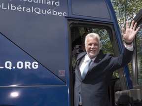 Quebec Liberal Leader Philippe Couillard waves as he boards his campaign bus, Thursday, August 23, 2018 as he launches the provincial election in Quebec City.