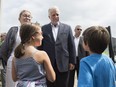 Quebec Liberal Leader Philippe Couillard, centre, speaks to children as he arrives at a college, Tuesday, August 28, 2018 in St-Agapit. Couillard's wife, Suzanne Pouliot, left, looks on.